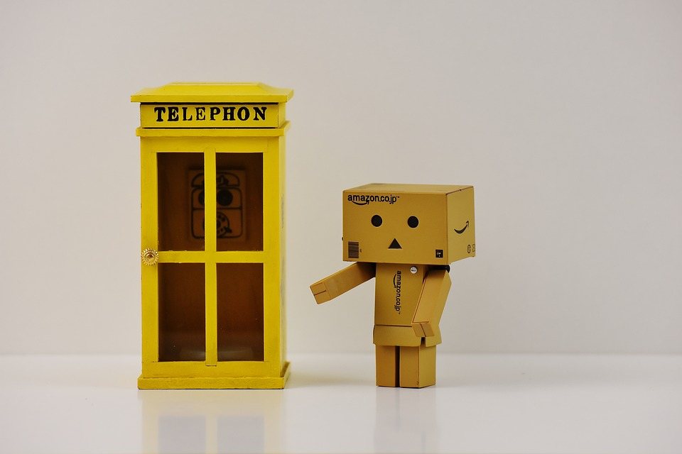 cardboard man standing beside telephone booth 
