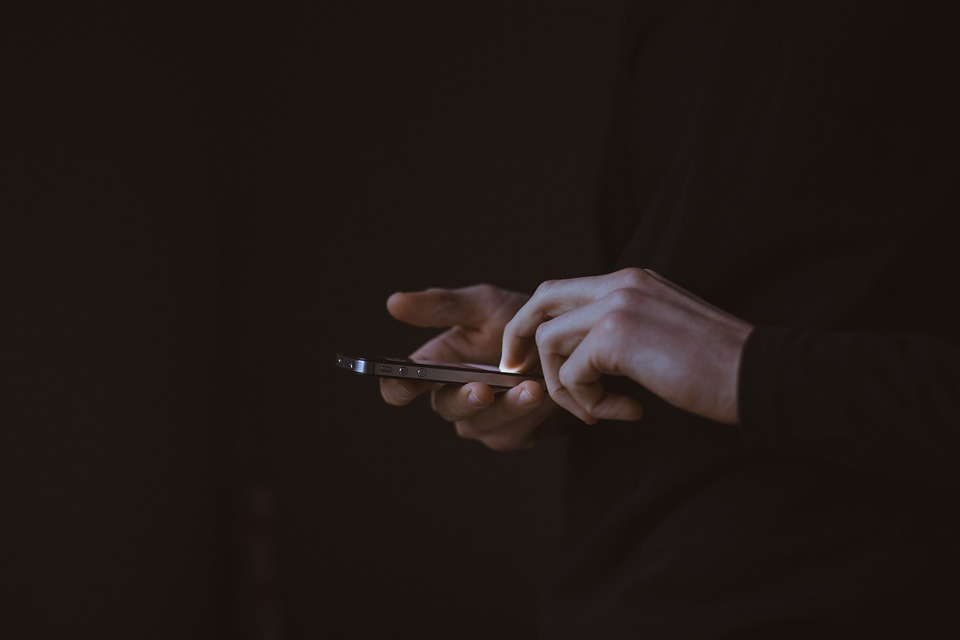 dark image of person using iOS iphone smartphone