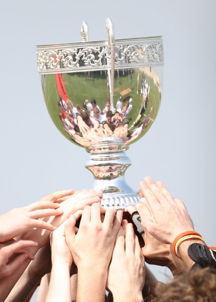soccer teammates holding up a trophy together