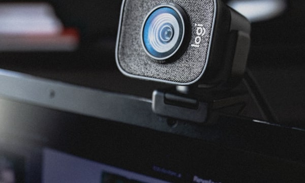 Close-up, angled view of standalone web camera attached to the top of laptop